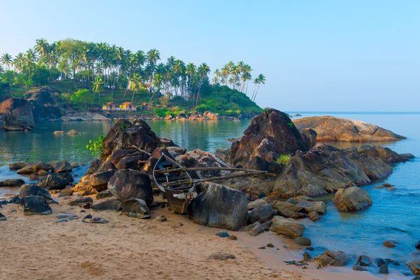 Altes Boot in den Felsen am Strand von Goa — Stockfoto