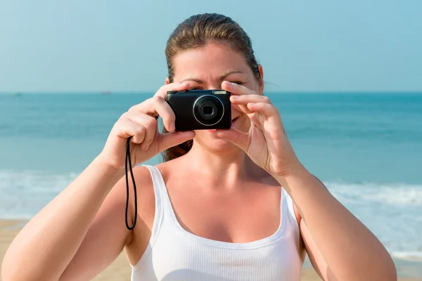 Portrait of a girl with a camera on the beach — Stock Photo, Image