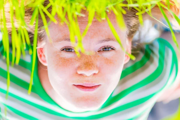 Een groot portret van een meisje in een weiland met gras — Stockfoto