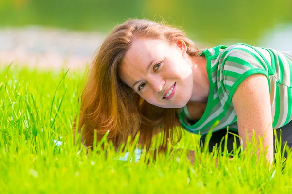 Porträtt av charmiga tjejen i grön t-shirt på gräset — Stockfoto