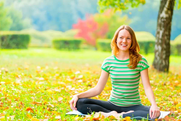 Sonbahar parkta bekletin. kadın uygulamaları yoga niteliğine — Stok fotoğraf