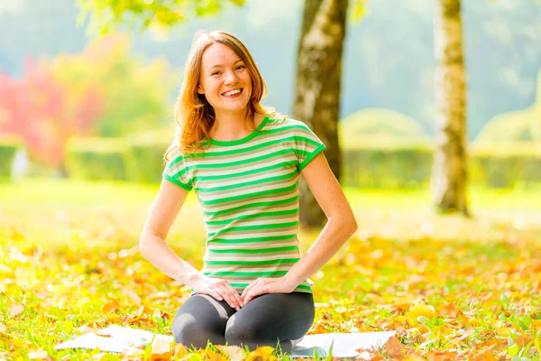 Yoga im Herbstpark. Mädchen zwischen den Bäumen beim Yoga — Stockfoto