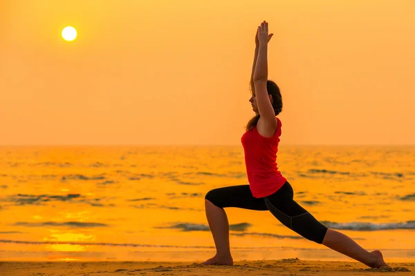 Frau macht Yoga bei Sonnenuntergang in der Nähe des Ozeans — Stockfoto