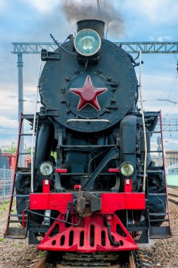 old steam locomotive with smoke travels on rails