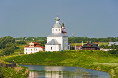 Orthodox church on the green lawn near the river, the city of Su