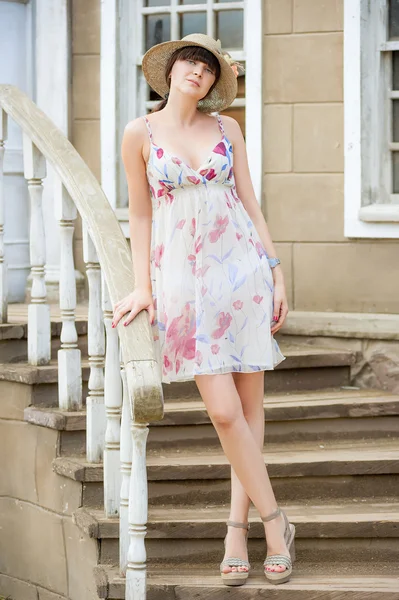 Girl in the hat and summer sundress on the stairs — 스톡 사진