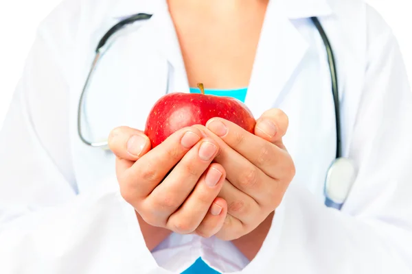 Hands of the doctor with a red apple close up — Stock Photo, Image