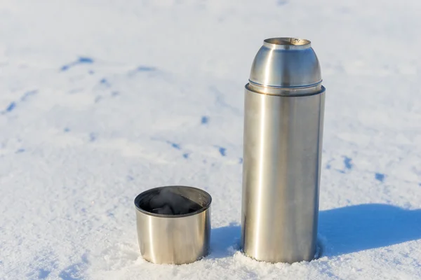 Open thermos with boiling water in the snow in the winter — 图库照片