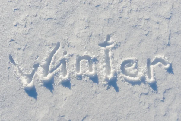 Winter word written on the snow surface — Stockfoto