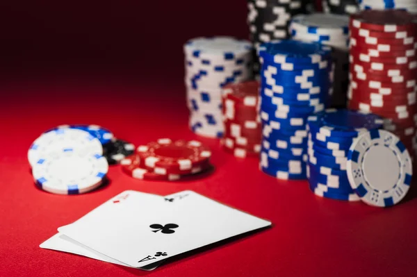 Kaarten en poker chips op een rode doek — Stockfoto