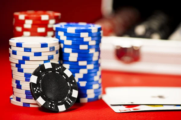 Stapel bunter Pokerchips auf einem roten Tisch — Stockfoto