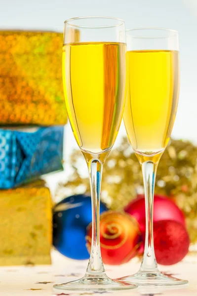 Two glasses with champagne and Christmas gifts — Stock Photo, Image
