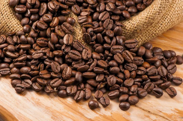 Roasted coffee beans on a rough sackcloth closeup — Stock Photo, Image