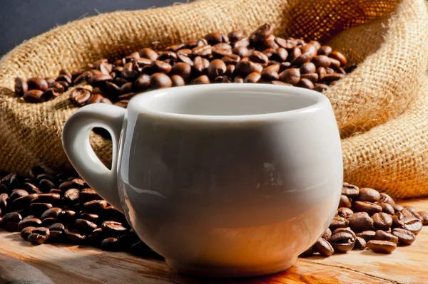 Closeup osvěžující nápoj v šálku a kávová zrna — Stock fotografie