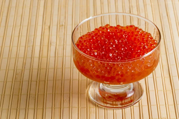 Skål med röd kaviar på en bambu servett närbild — Stockfoto