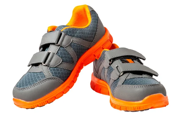 Детские кроссовки с ярко-оранжевой отделкой на белом фоне — стоковое фото