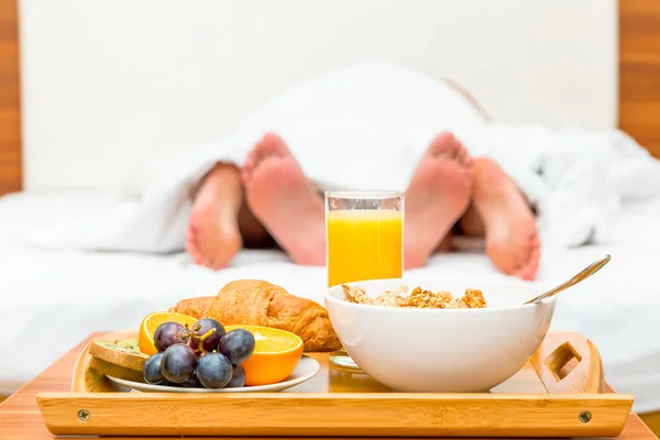 Coppia a letto, un vassoio di cibo a fuoco — Foto Stock