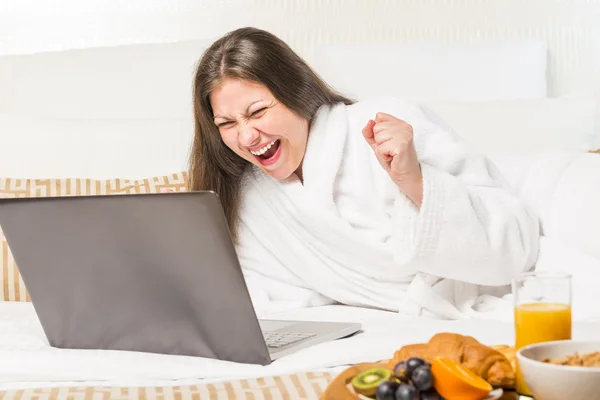 Emotional portrait of a happy woman looking at a laptop — Stockfoto