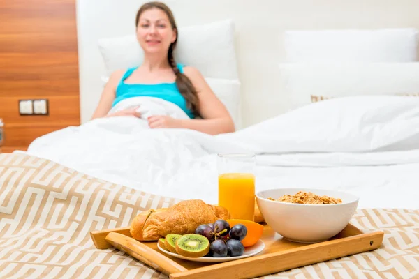 Desayuno en la cama de una habitación de hotel de una hermosa morena —  Fotos de Stock