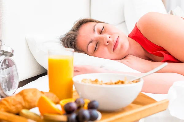 Breakfast on a tray beside the bed sleeping girl — Stock Photo, Image