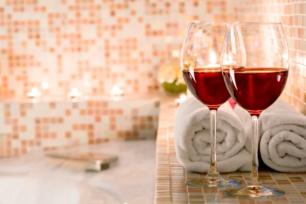 Two glasses of wine and burning candles close-up in the bathroom — Stock Photo, Image