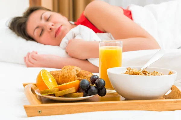 Healthy breakfast in focus and sleeping girl — Stock Photo, Image