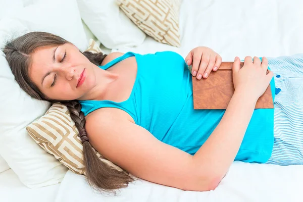 Portrait of a girl asleep with a book in bed — Stock Photo, Image