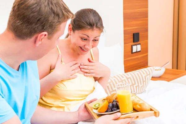Kobieta była mile zaskoczony przez śniadanie w łóżku — Zdjęcie stockowe