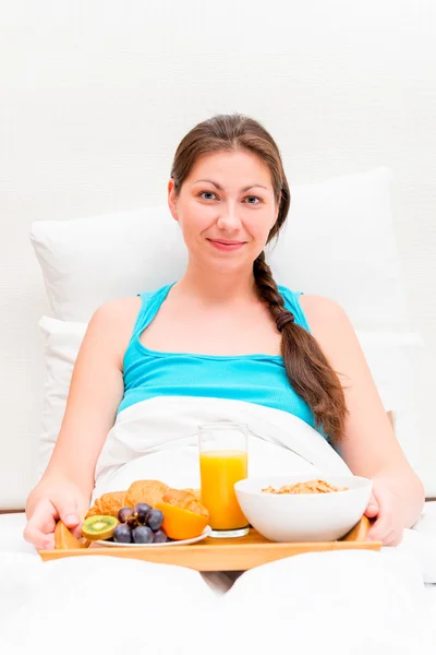 Bir kadınla yatakta kahvaltı sabah bir tepsi — Stok fotoğraf