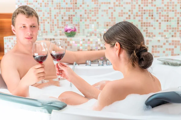 Ein Ehepaar mit einem Glas Wein im Whirlpool — Stockfoto