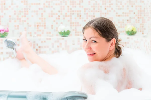 Één meisje zit in de jacuzzi met schuim — Stockfoto