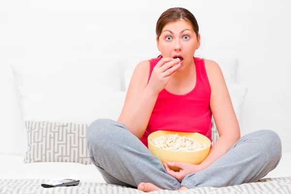 Perempuan penuh perhatian menonton TV dan makan popcorn — Stok Foto