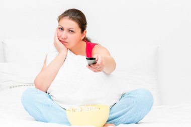 Pijama bir Tv uzaktan kumanda ile memnun kız