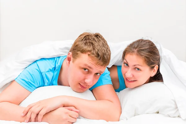 Portrait men and women 30 years old in bed under a blanket — Stock Photo, Image