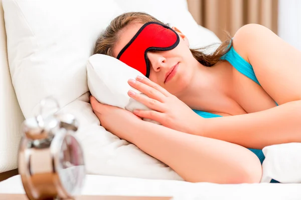 Girl with a red eye mask sleeping alone — Stock Photo, Image