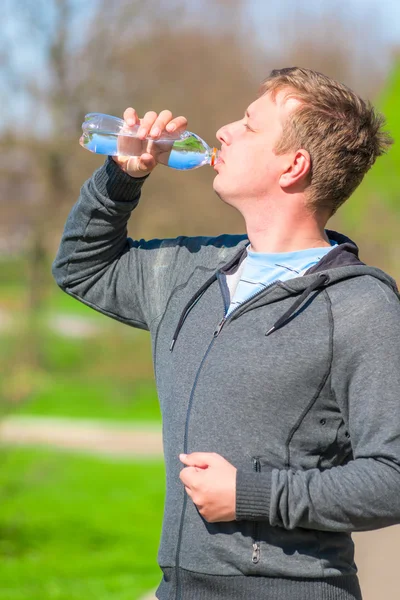 Um jovem com uma garrafa de água — Fotografia de Stock