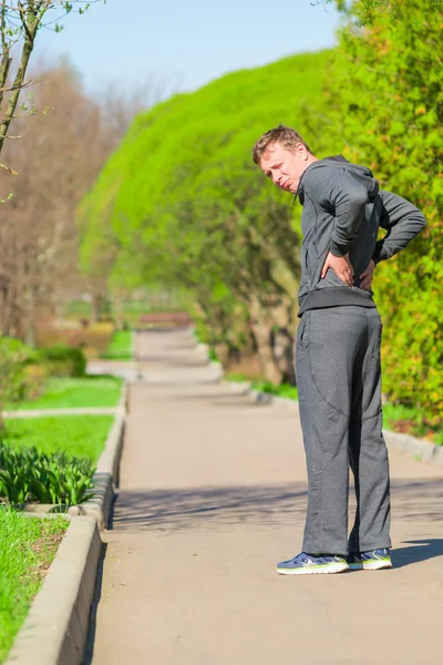 Jogging yaparken bir adam sırt ağrısı başladı — Stok fotoğraf