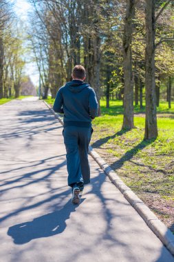 Şehir Parkı içinde çalışan spor elbiseli bir adam