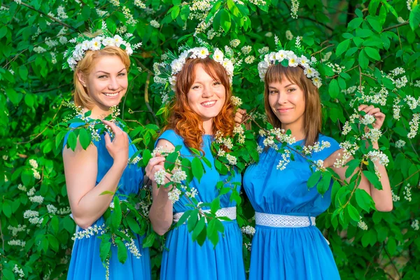Tre ragazze felici in abiti identici in posa in giardino in s — Foto Stock