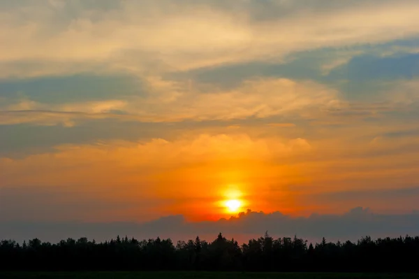 Prachtige ondergaande zon in oranje tinten — Stockfoto