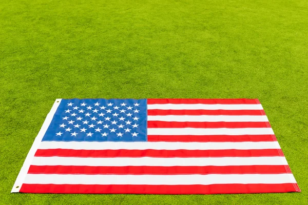 Yeşil çimenlerin üzerinde yazıt için yer ve Amerikan bayrağı — Stok fotoğraf