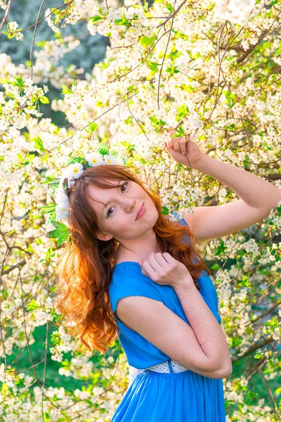 Vertical portrait of a red-haired girl with a cherry tree — Stock Photo, Image