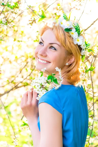 Happy young beautiful girl in a cherry blossom — Stock Photo, Image