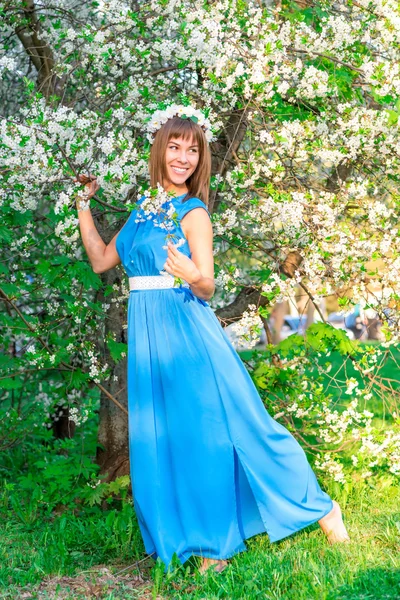 Morena feliz posando cerca del árbol en el momento de la floración che —  Fotos de Stock