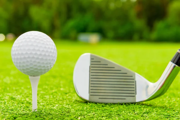 Белый мяч на ти и гольф-клуб на поле — стоковое фото