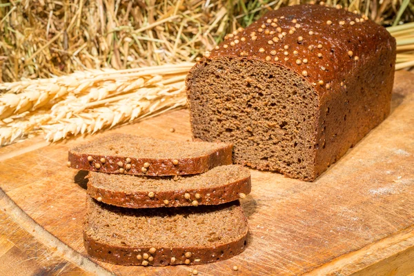 Delicious flavored bread on the background of dried hay and whea — Stock Photo, Image