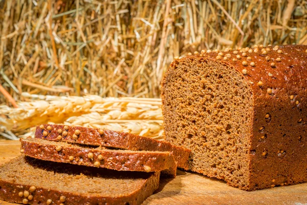 Pan de centeno en rodajas de cerca sobre un fondo de heno —  Fotos de Stock