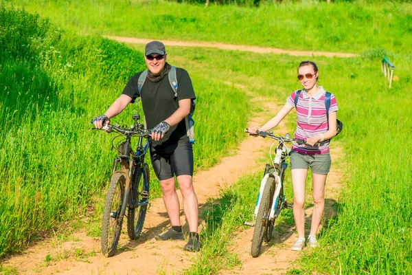 Heureux jeune couple marchant avec des vélos — Photo