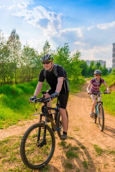 Familia joven en bicicleta haciendo ejercicio en una carretera rural — Foto de Stock