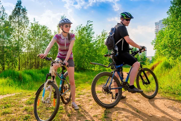 Ciclistas en cascos y gafas de sol descansando en una colina —  Fotos de Stock